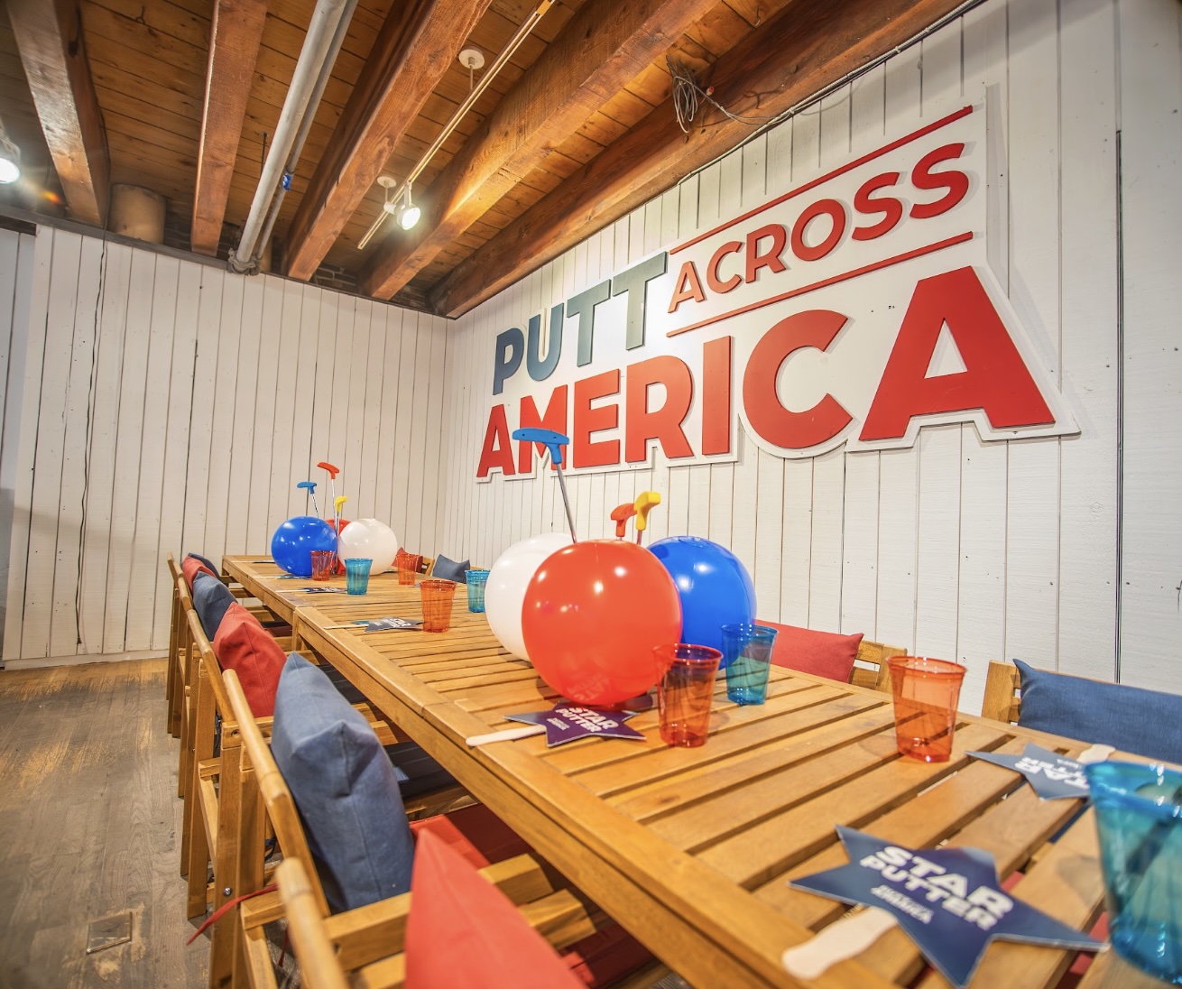 Party table set up under the Putt Across America sign