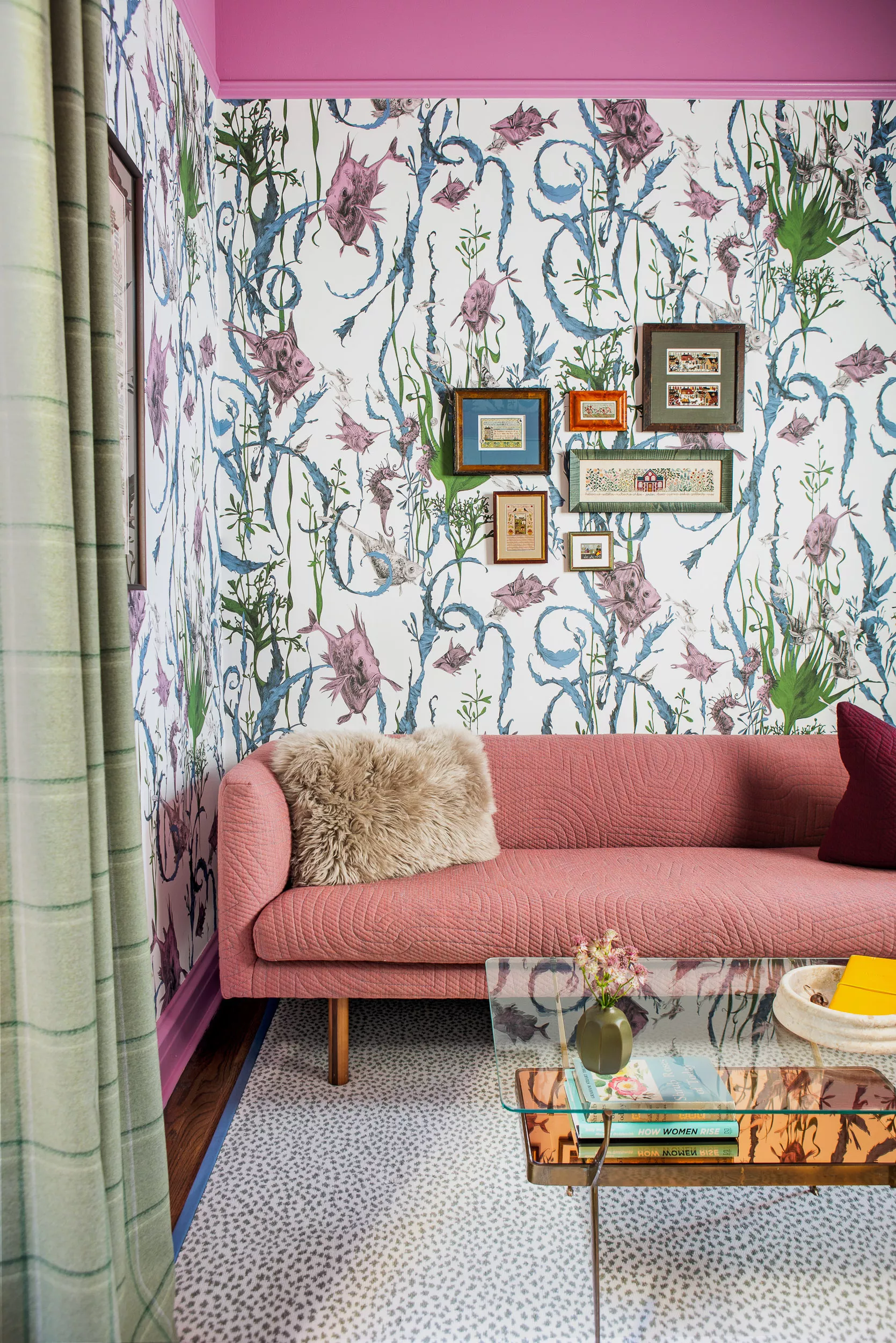 Room with fish wallpaper, a pink couch, and a gallery wall