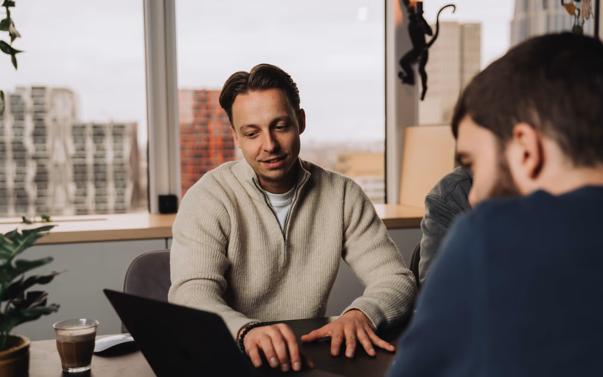 Overleg tussen collega’s aan tafel met laptop.