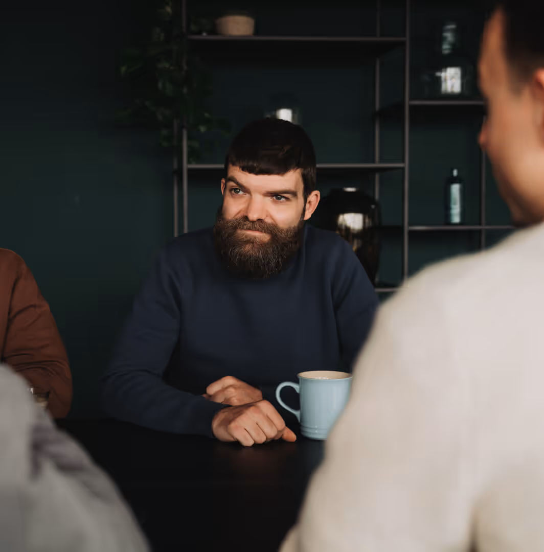 Man in gesprek tijdens een overleg aan tafel.