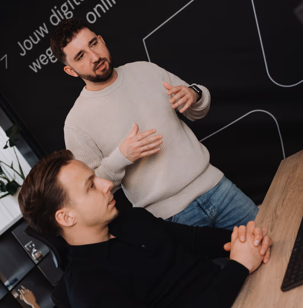 Twee collega’s in gesprek tijdens een werkoverleg.