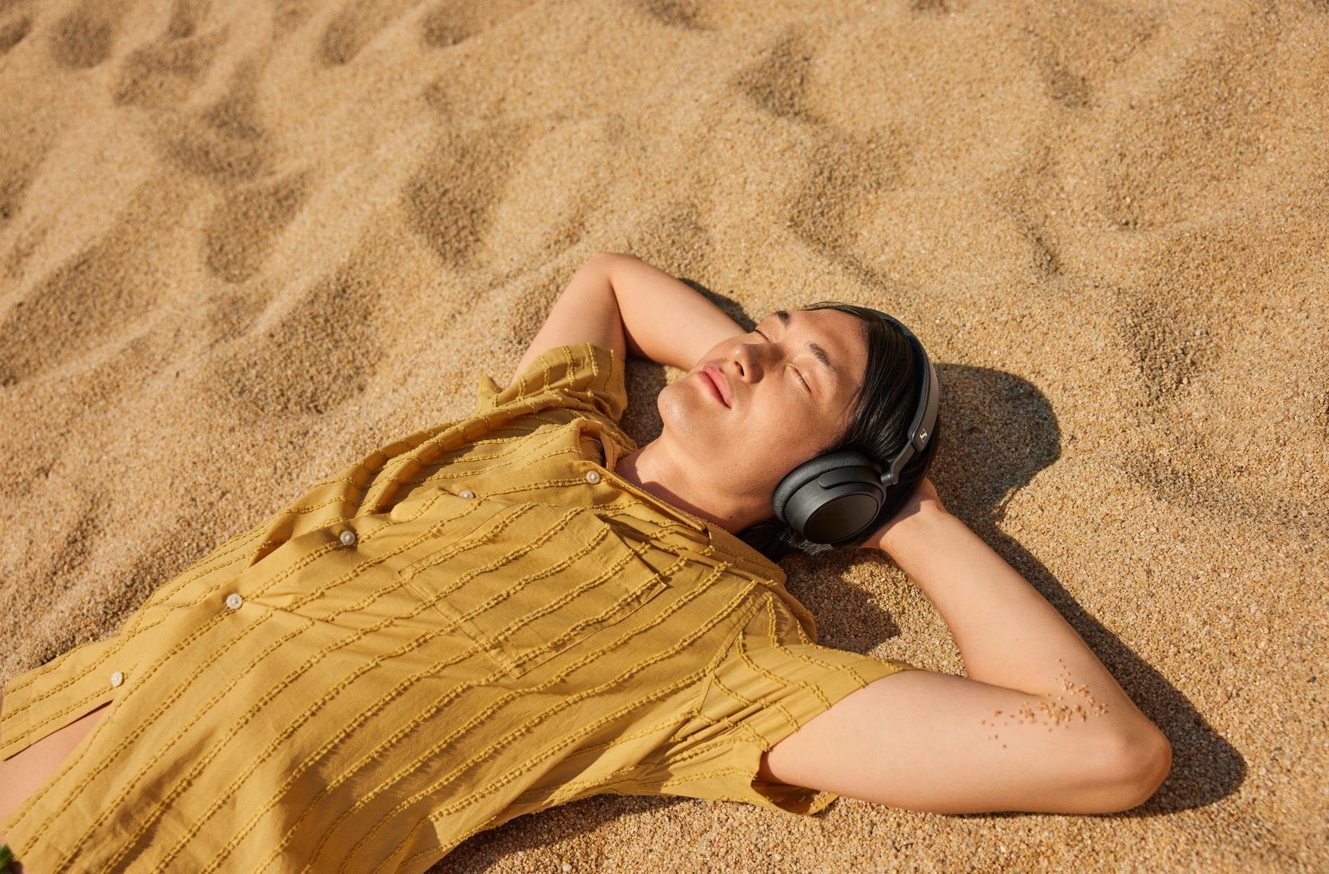 Sennheiser Accentum Plus in zwart gedragen op het strand