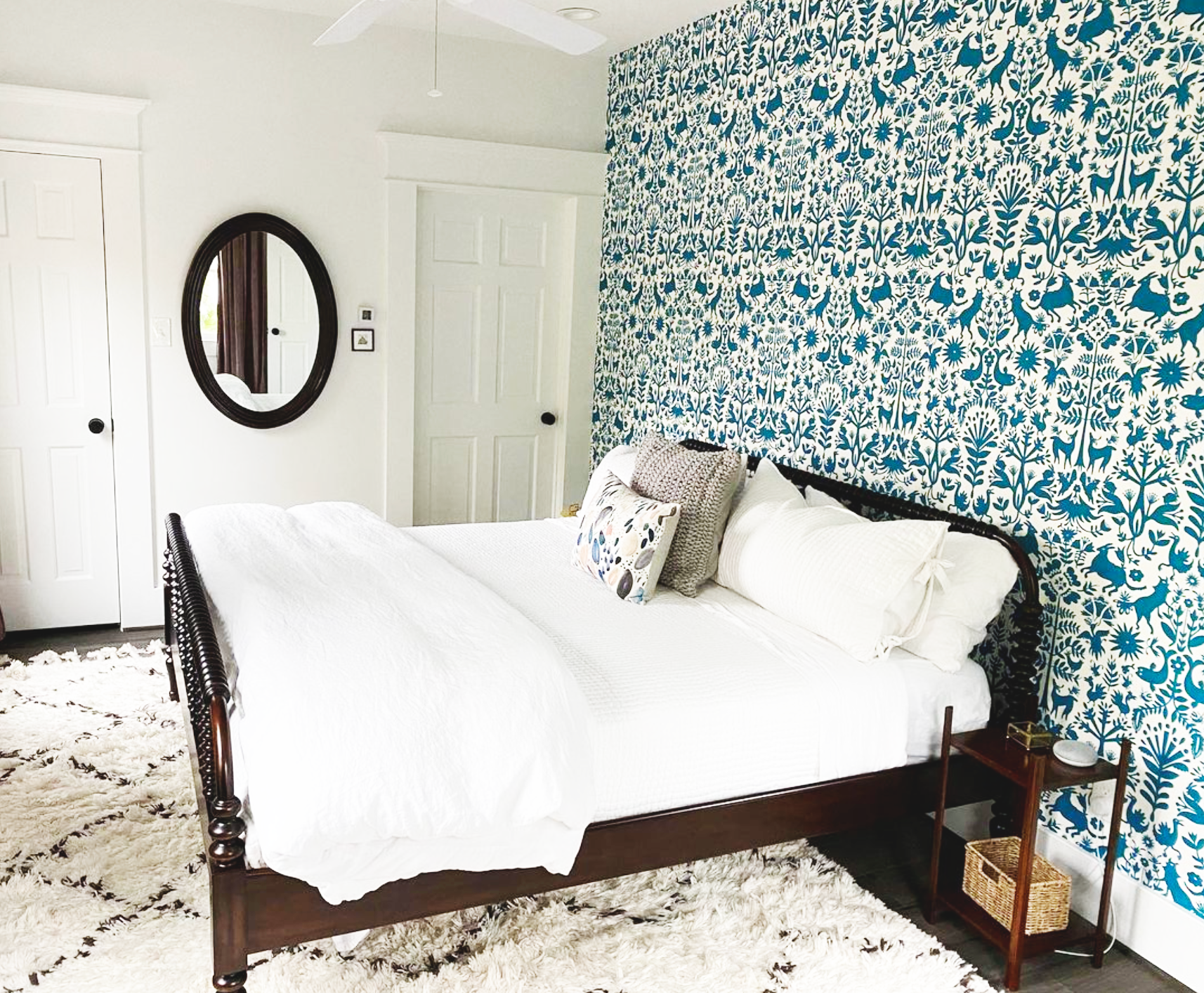 This cozy bedroom features a blue and white floral patterned wall.