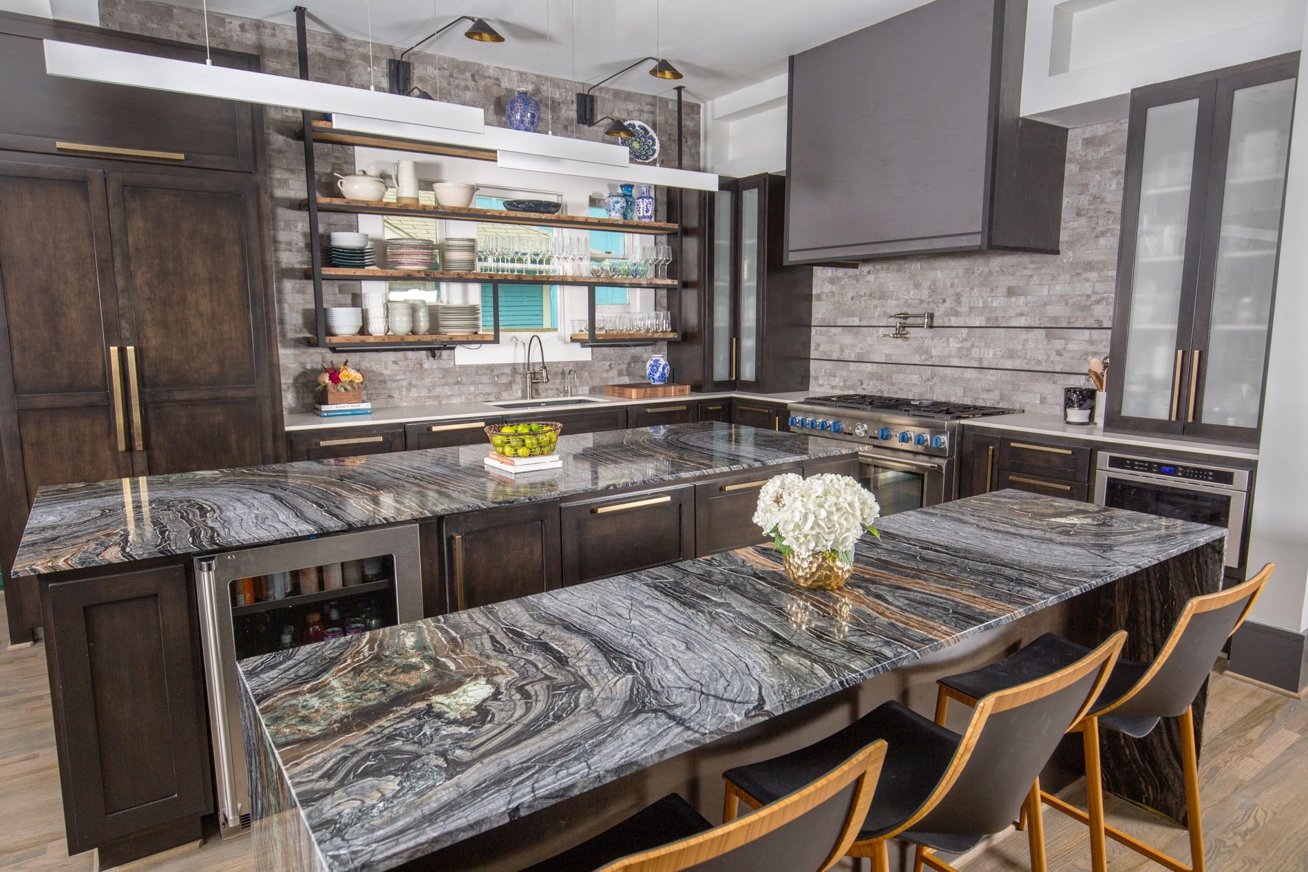 This kitchen is adorned with marble countertops and luxury material for the pantries. Every selection in this renovated kitchen shines.