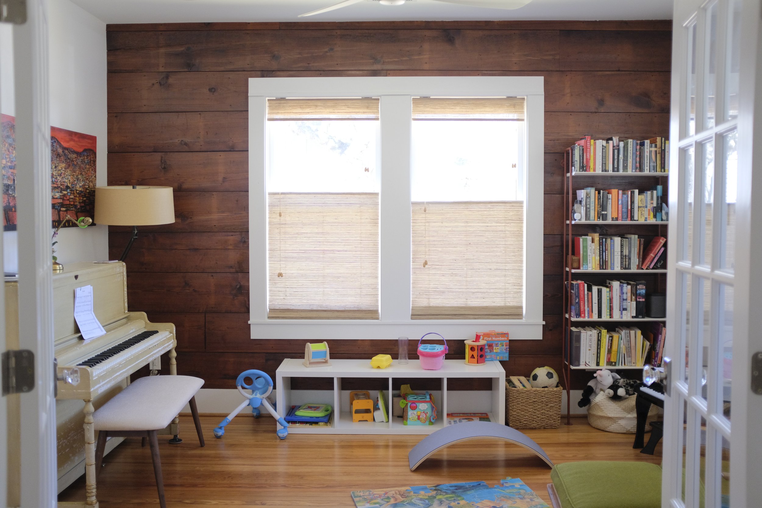 This library room features wood siding and wood floors that give a warm and inviting aura for children to explore, read and play.
