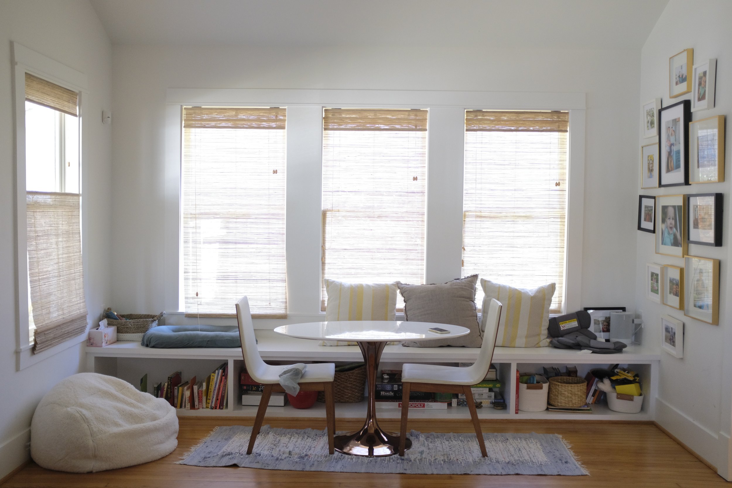 This renovated entry room features furniture that is low to the ground and inviting as a breakfast nook or reading room.