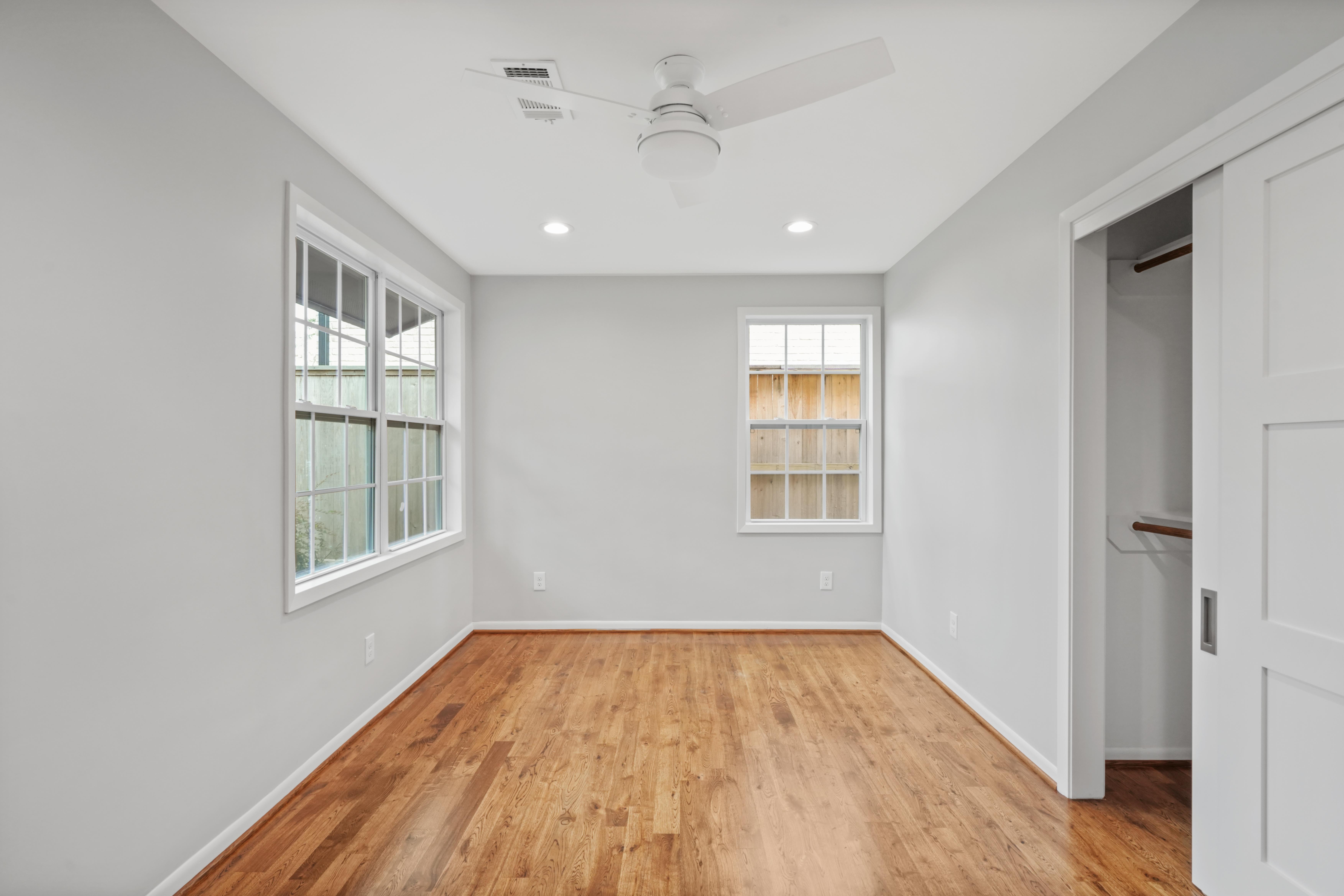 This empty room features neutral gray walls that are complimented by wood floors. The renovation feels natural and inviting.