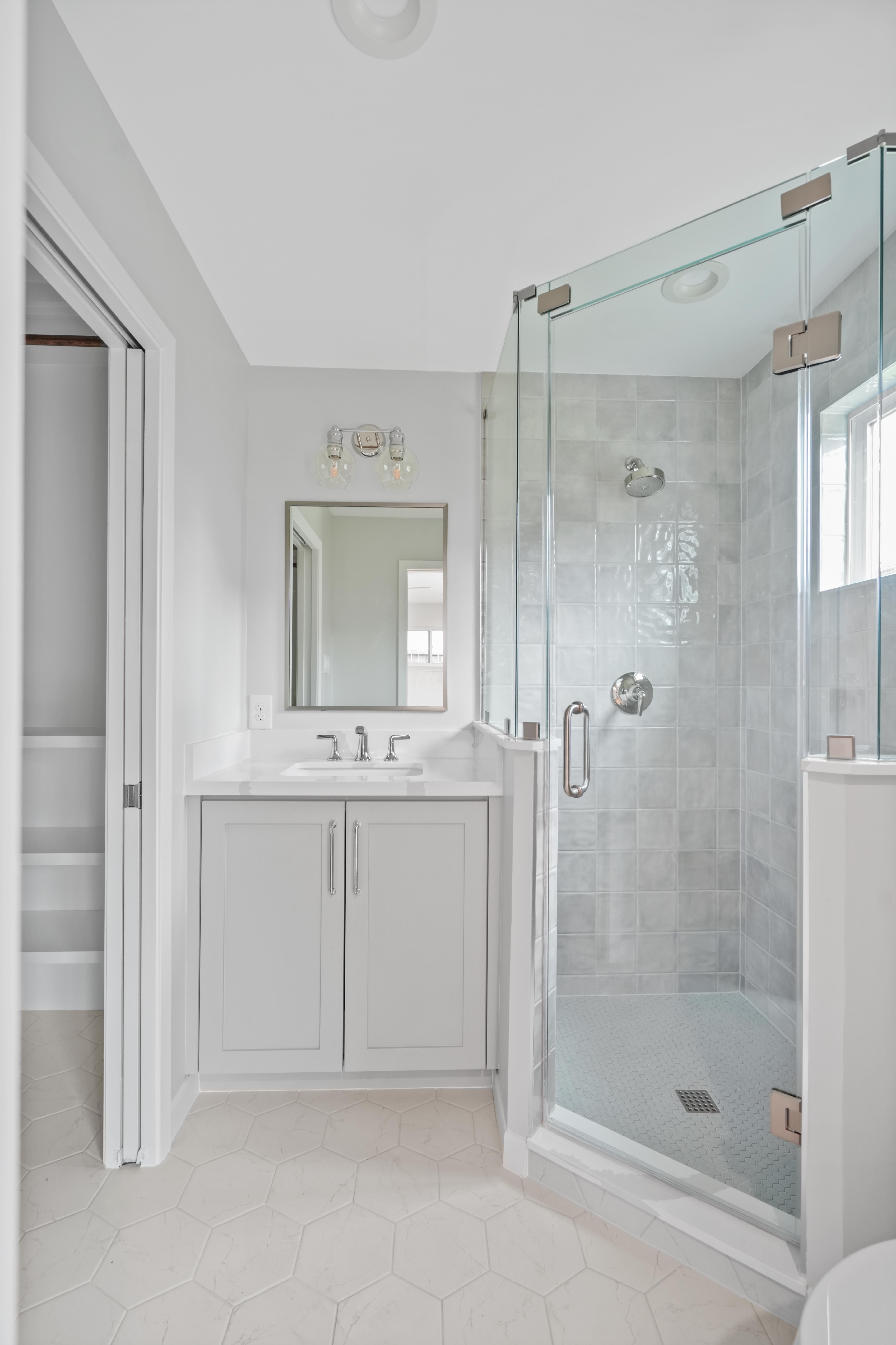 This bathroom exudes elegance with it's simple white color scheme and it's glass door fixture for the standing shower. The tile selection in the shower compliments the rest of the ensemble.