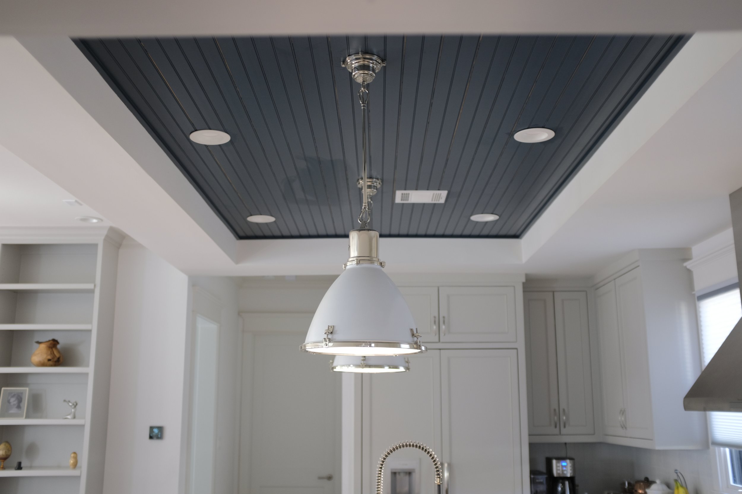 A detail shot of the overhead light selection in this renovated kitchen exudes simple elegance.