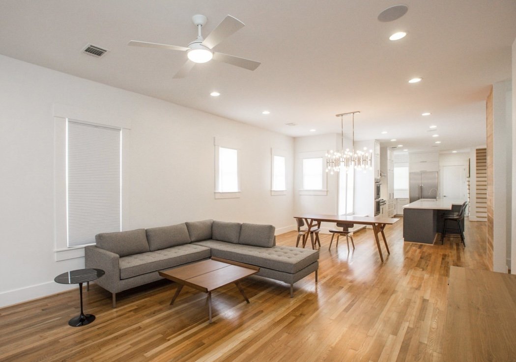 This living room features elegant minimalism with low profile couch and wooden floors.