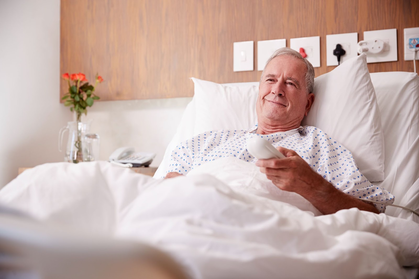A patient uses a remote control to navigate an in-room TV system.