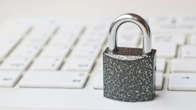 Imagem de um cadeado metálico sobre um teclado, simbolizando segurança e proteção de dados. A importância da segurança digital é essencial para usuários.