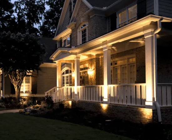 outdoor lighting shining up onto the columns of a home