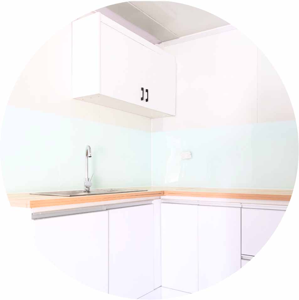 Minimalist white kitchen corner with wooden countertops, a stainless steel sink, and upper and lower cabinets.