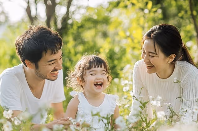 Glückliche Familie lacht zusammen im Garten