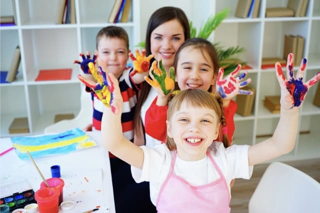 Kinder und Erzieherin beim kreativen Malen