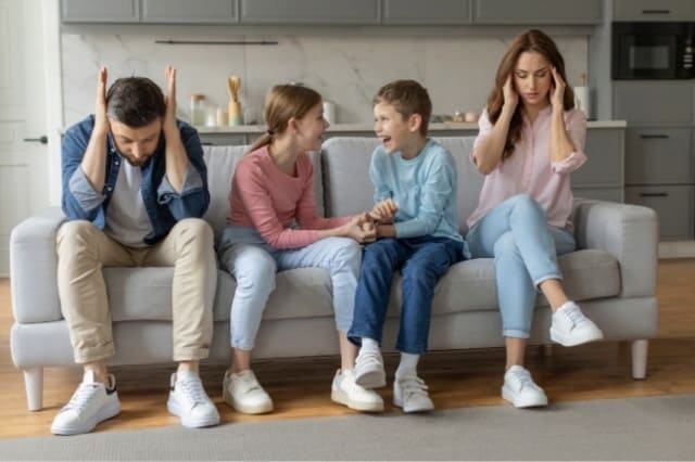 Eltern streiten und Kinder lachen auf dem Sofa
