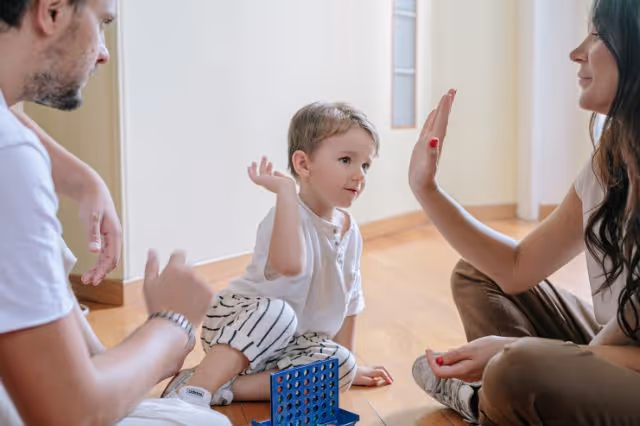 Junge spielt mit Eltern ein Spiel