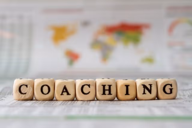 Holzwürfel bilden das Wort Coaching auf Tisch
