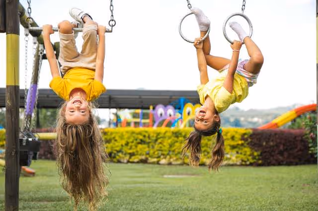 Kinder hängen kopfüber an Turngeräten