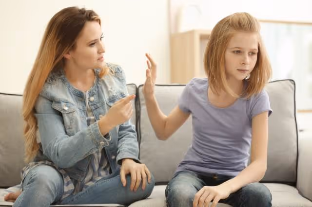 Mutter und Tochter streiten sitzend auf der Couch