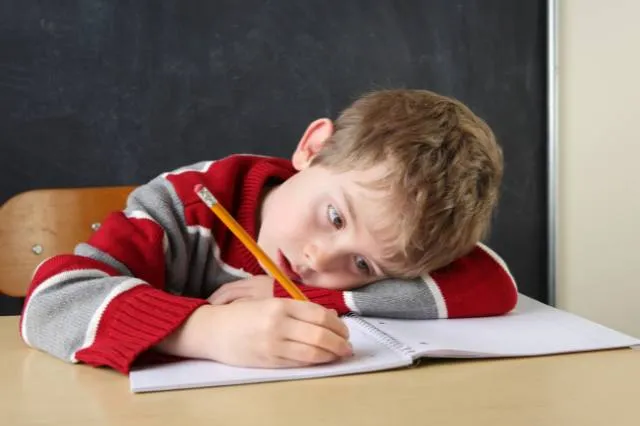 Schüler macht Hausaufgaben und ist erschöpft