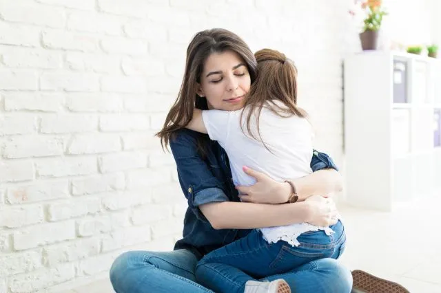 Mutter umarmt Tochter nach gewaltfreier Kommunikation