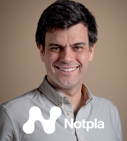 Hombre sonriente con camisa gris claro sobre fondo marrón con logo de Notpla en la esquina inferior izquierda.