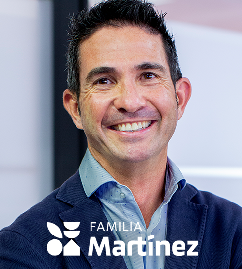 Hombre joven sonriendo con chaqueta azul y camisa azul claro, con logo de Familia Martínez.