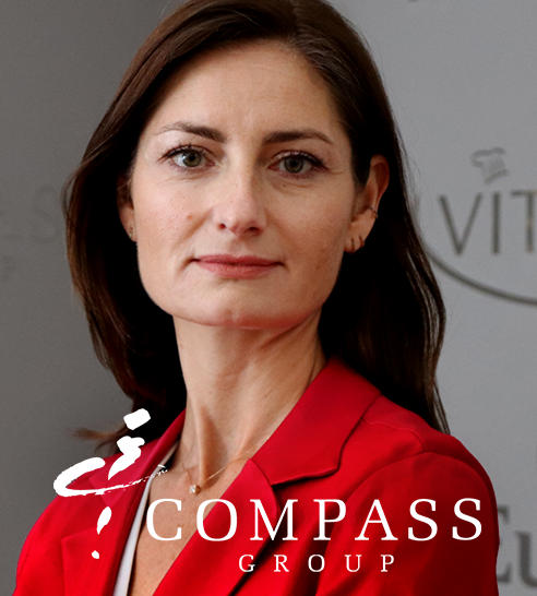 Mujer de cabello corto y oscuro sonriendo, vestida con blazer claro y pendientes de aro.