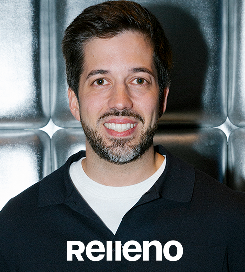 Mujer de cabello corto y oscuro sonriendo, vestida con blazer claro y pendientes de aro.