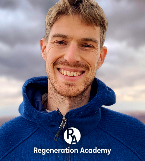 Mujer de cabello corto y oscuro sonriendo, vestida con blazer claro y pendientes de aro.