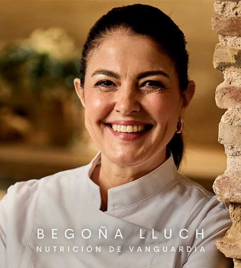 Mujer de cabello corto y oscuro sonriendo, vestida con blazer claro y pendientes de aro.
