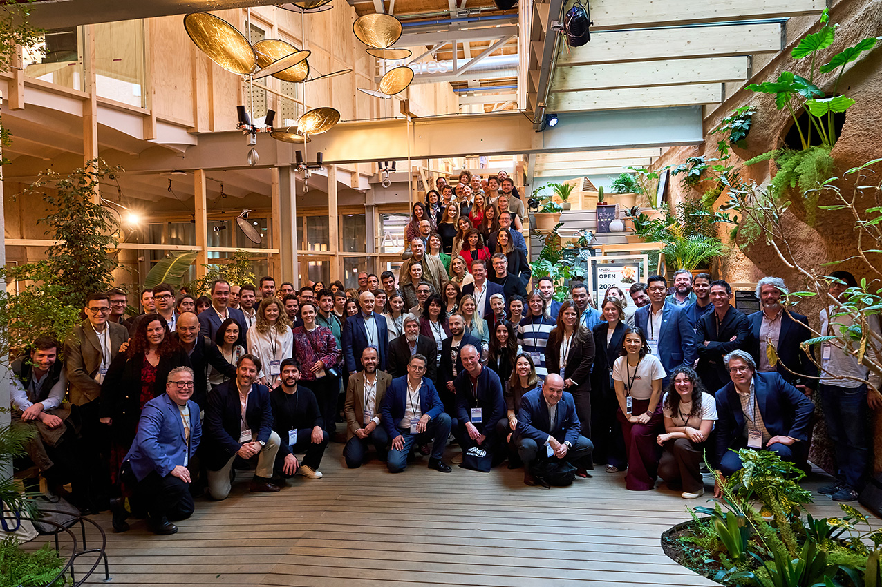 Grupo de nueve personas posando juntas en un evento nocturno, con dos personas sosteniendo premios.