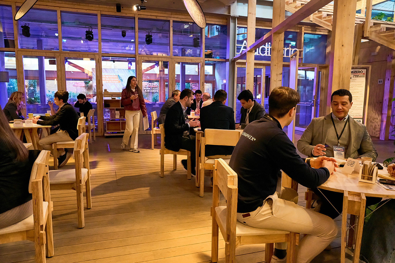 Grupo de nueve personas posando juntas en un evento nocturno, con dos personas sosteniendo premios.