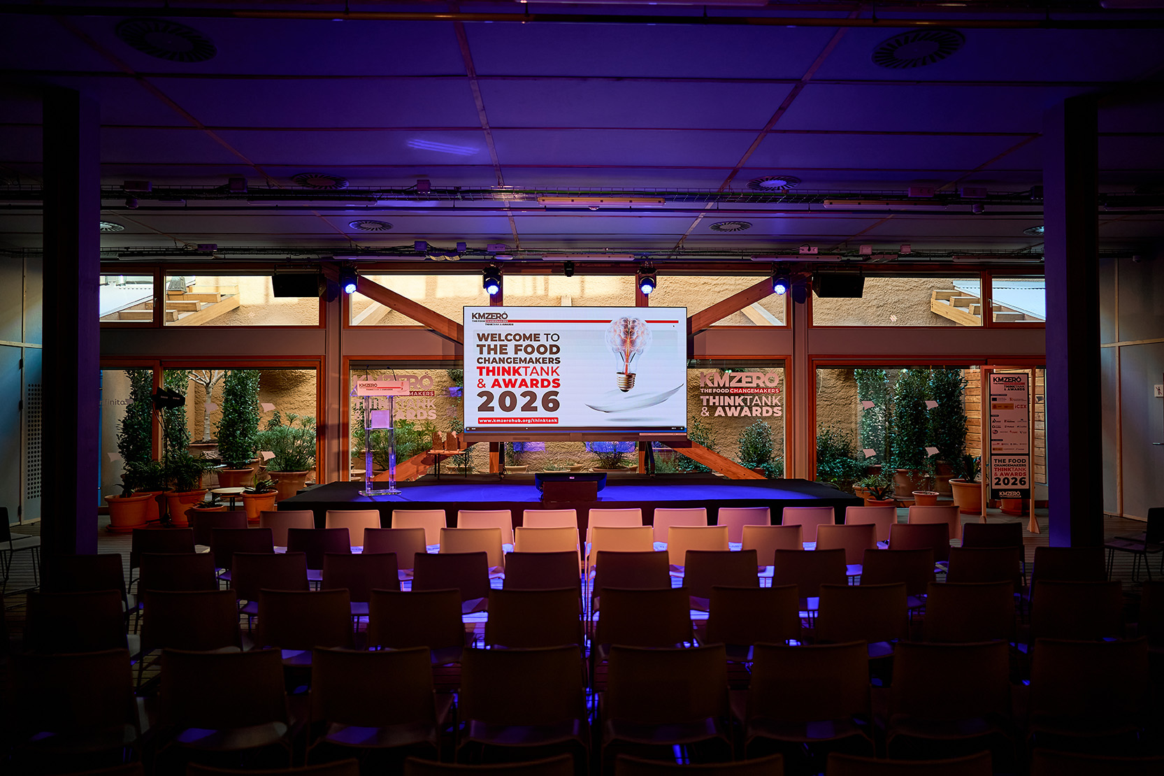Grupo de nueve personas posando juntas en un evento nocturno, con dos personas sosteniendo premios.