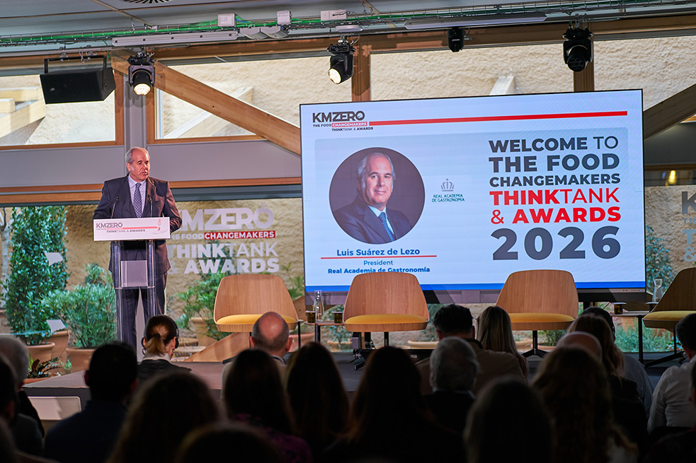 Grupo de nueve personas posando juntas en un evento nocturno, con dos personas sosteniendo premios.