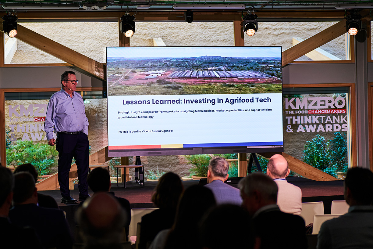Dos personas conversando en una mesa en un entorno de oficina o reunión.