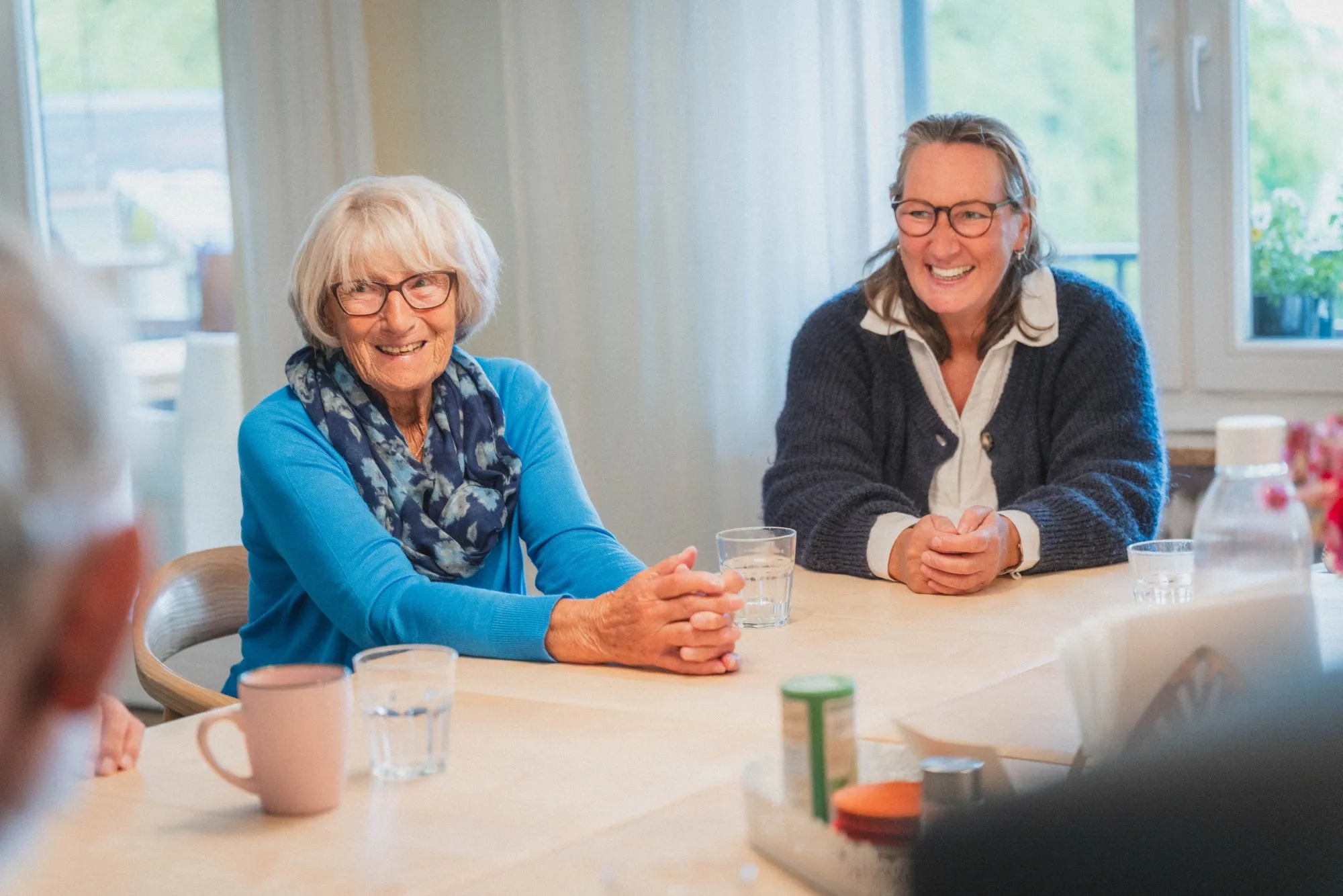 Mitarbeiter:innen des Pflegedienstes im Gespräch mit Bewohnern.