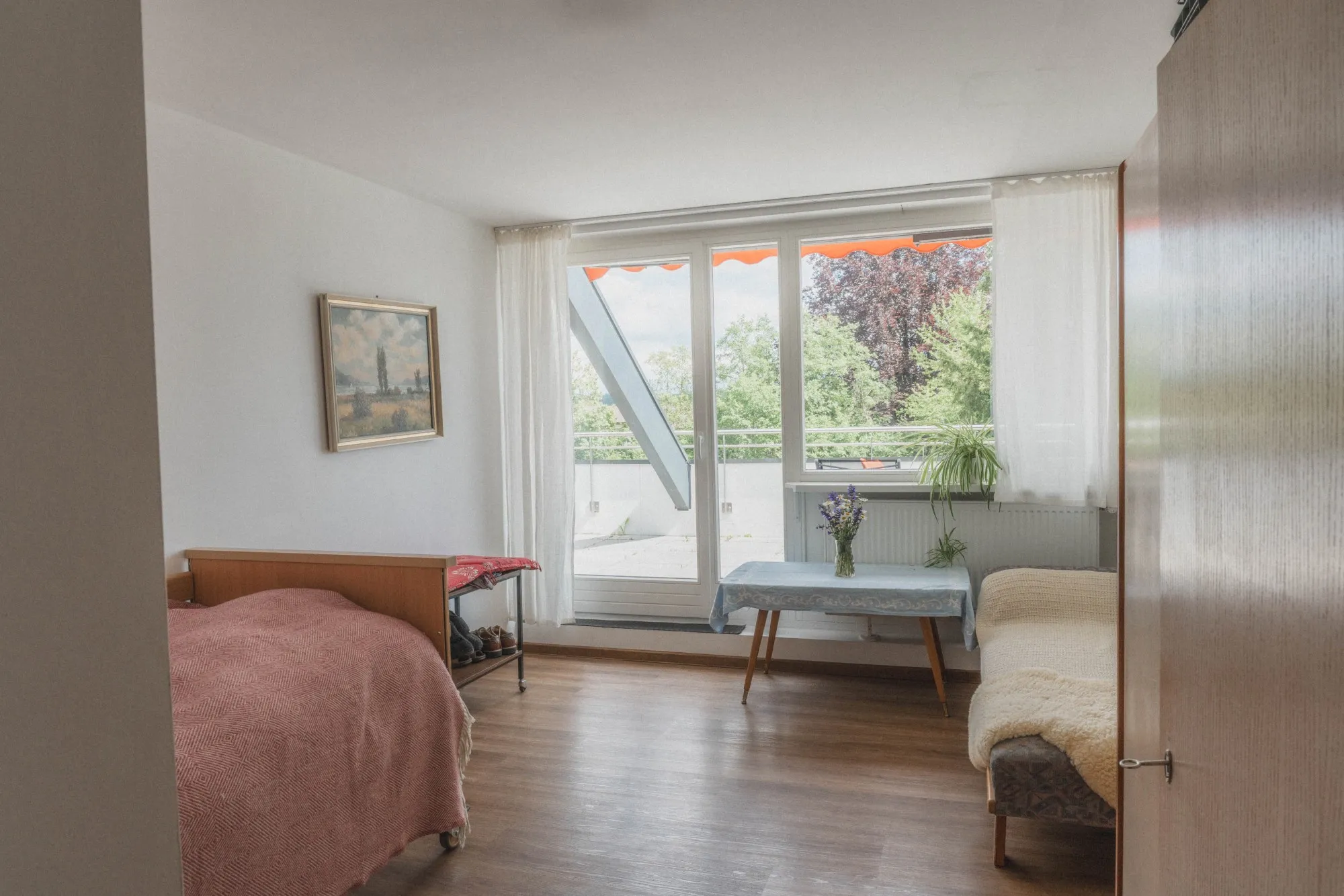 Einladendes Wohnzimmer mit bequemen Sesseln und großen Fenstern im Pflegeheim lebenswert.