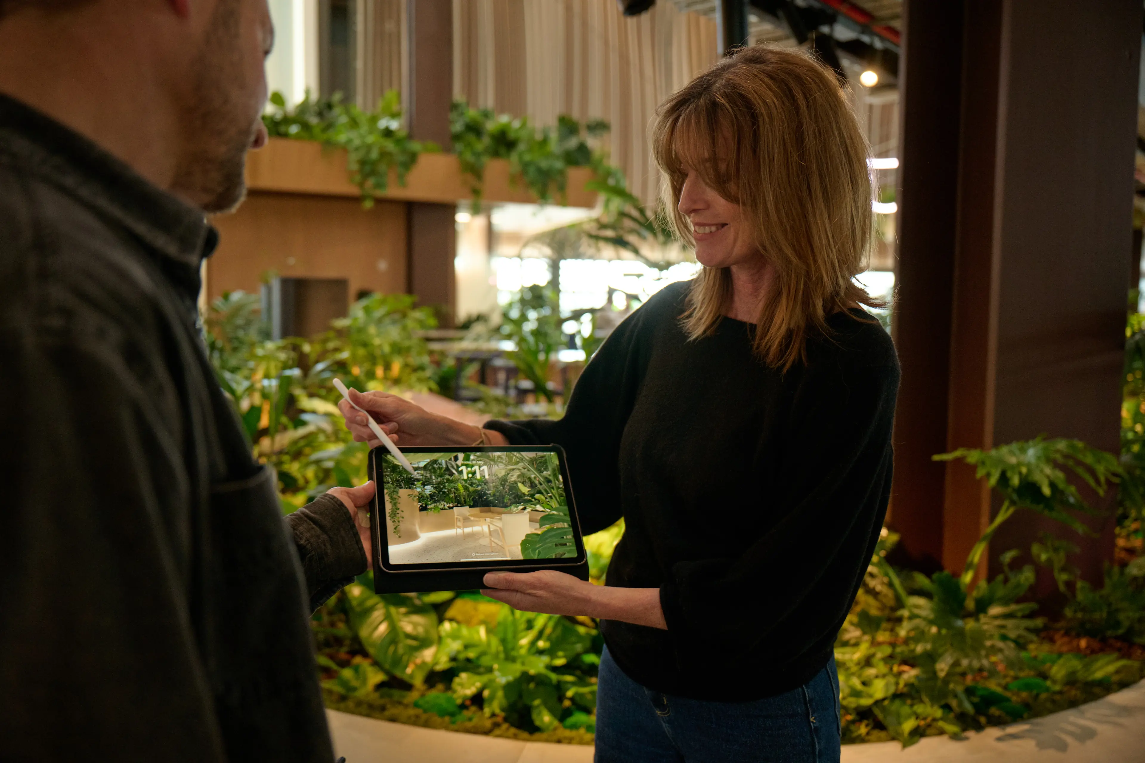 Sarah-Jane Challis, Designer at Outside In, showing a greenery concept on an iPad