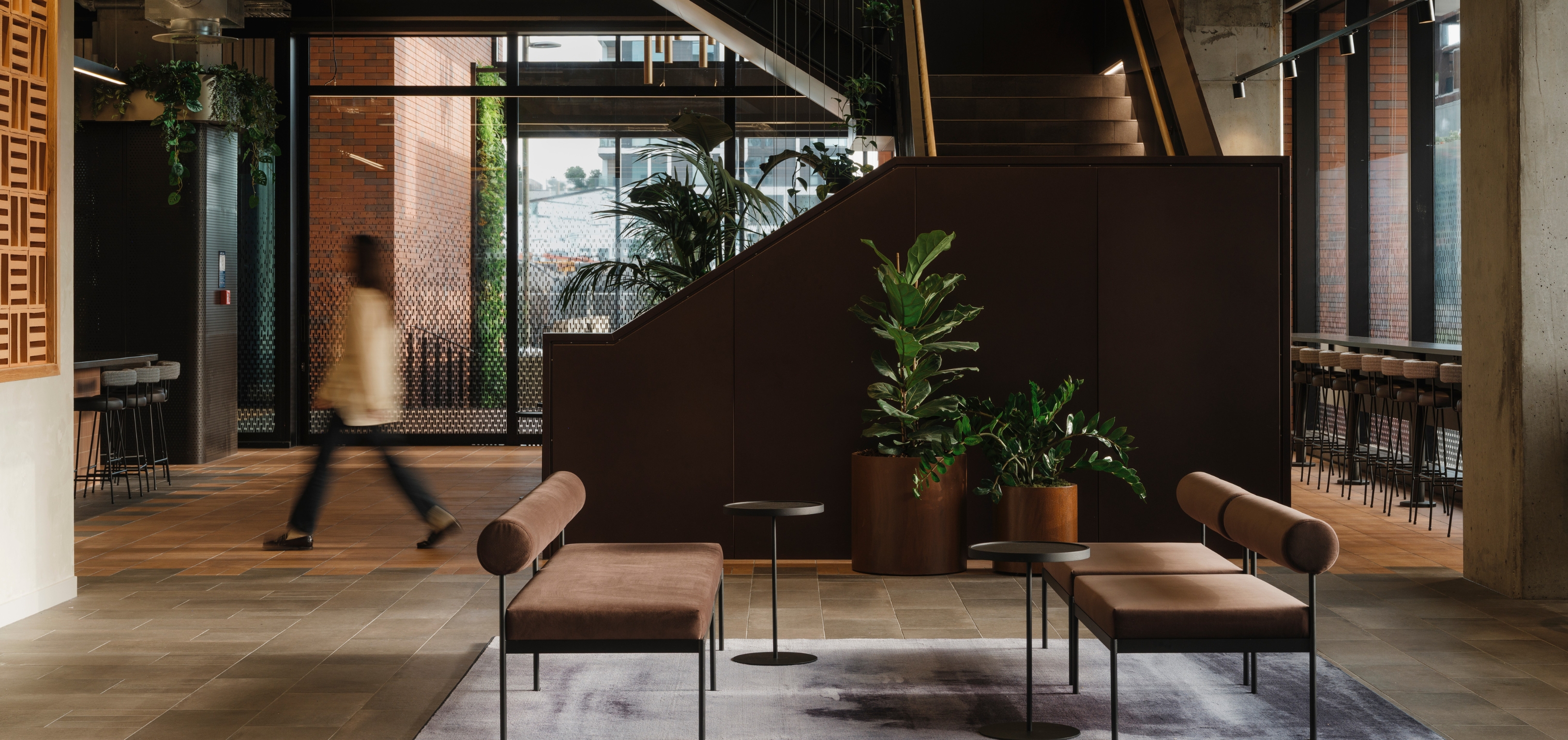 Layered greenery throughout the Mott MacDonald workplace creates a more connected and people-focused environment within the contemporary office setting.