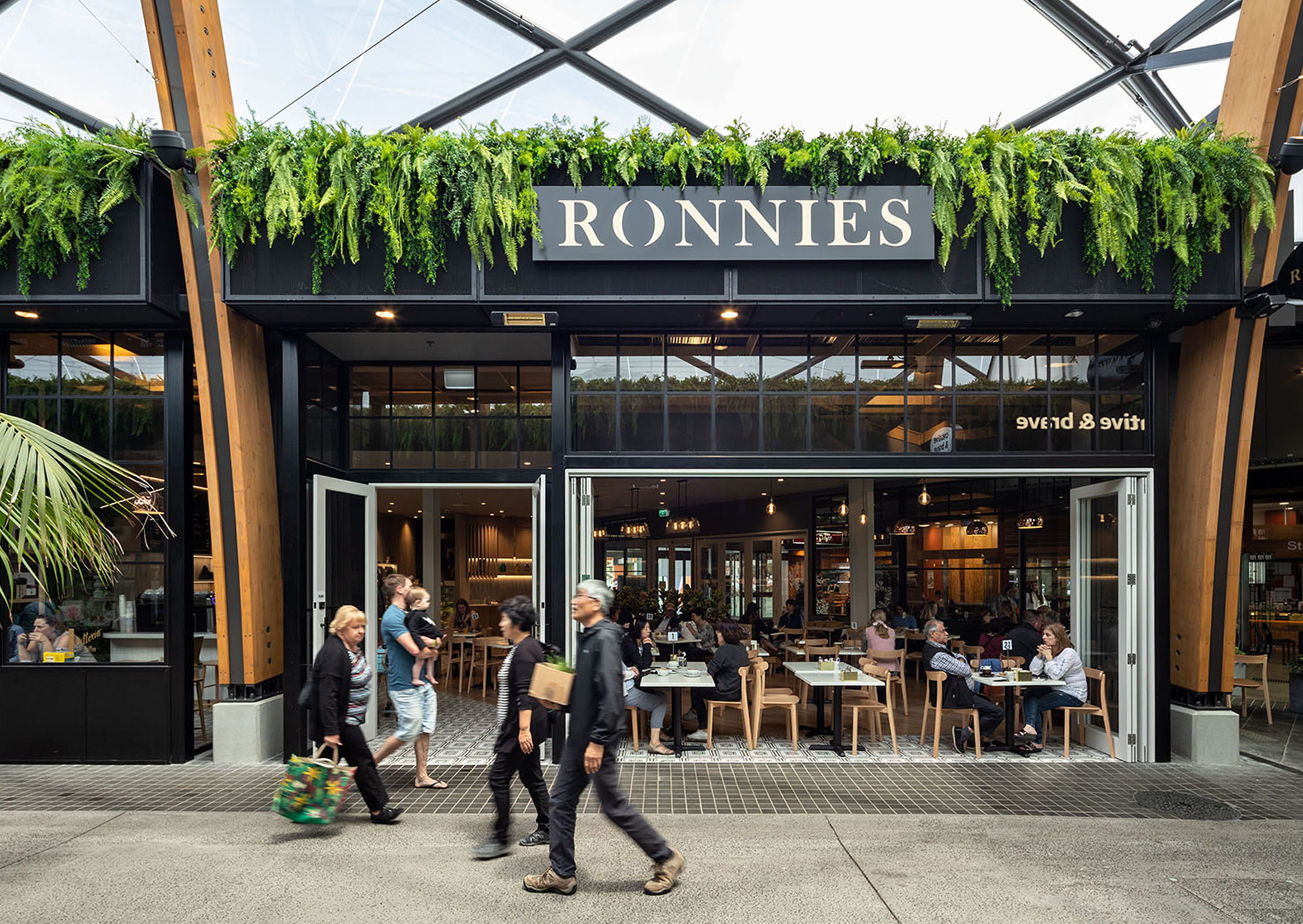 Trailing plants cascade over the Ronnies shopfront facade at Botany Town Centre.