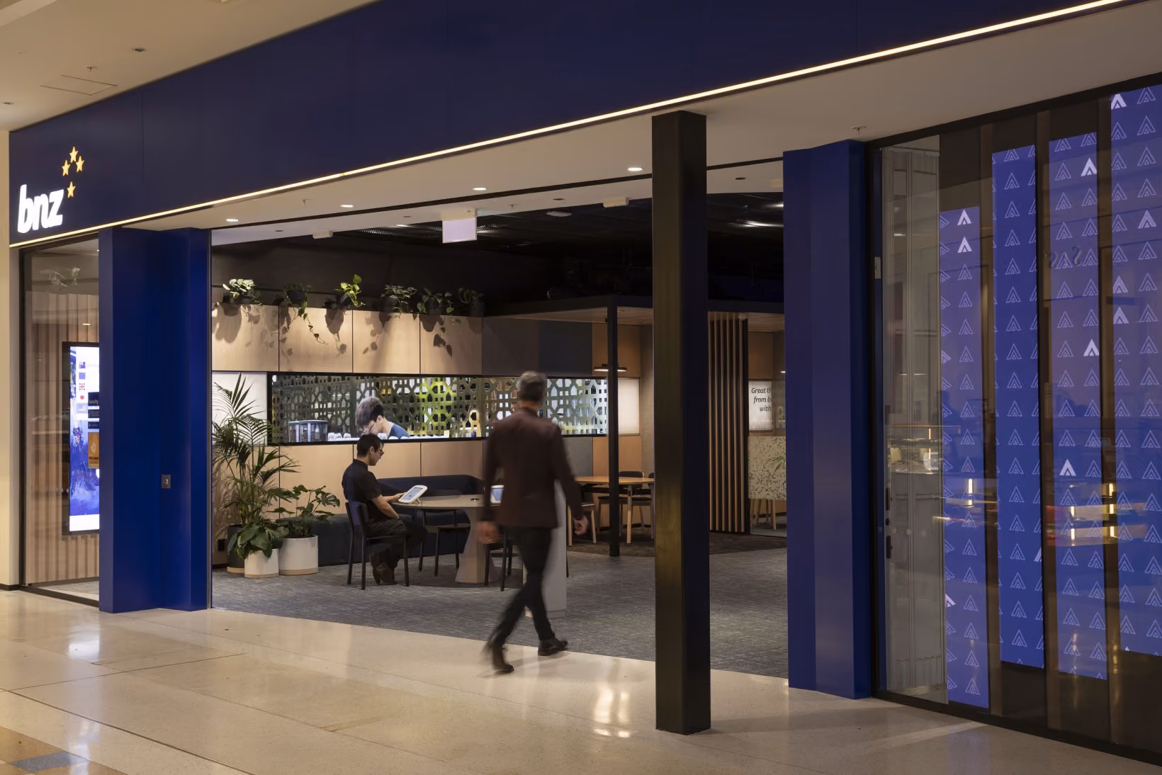 BNZ shopfront entrance in a mall, with palms and wall-mounted trailing plants visible inside the branch.