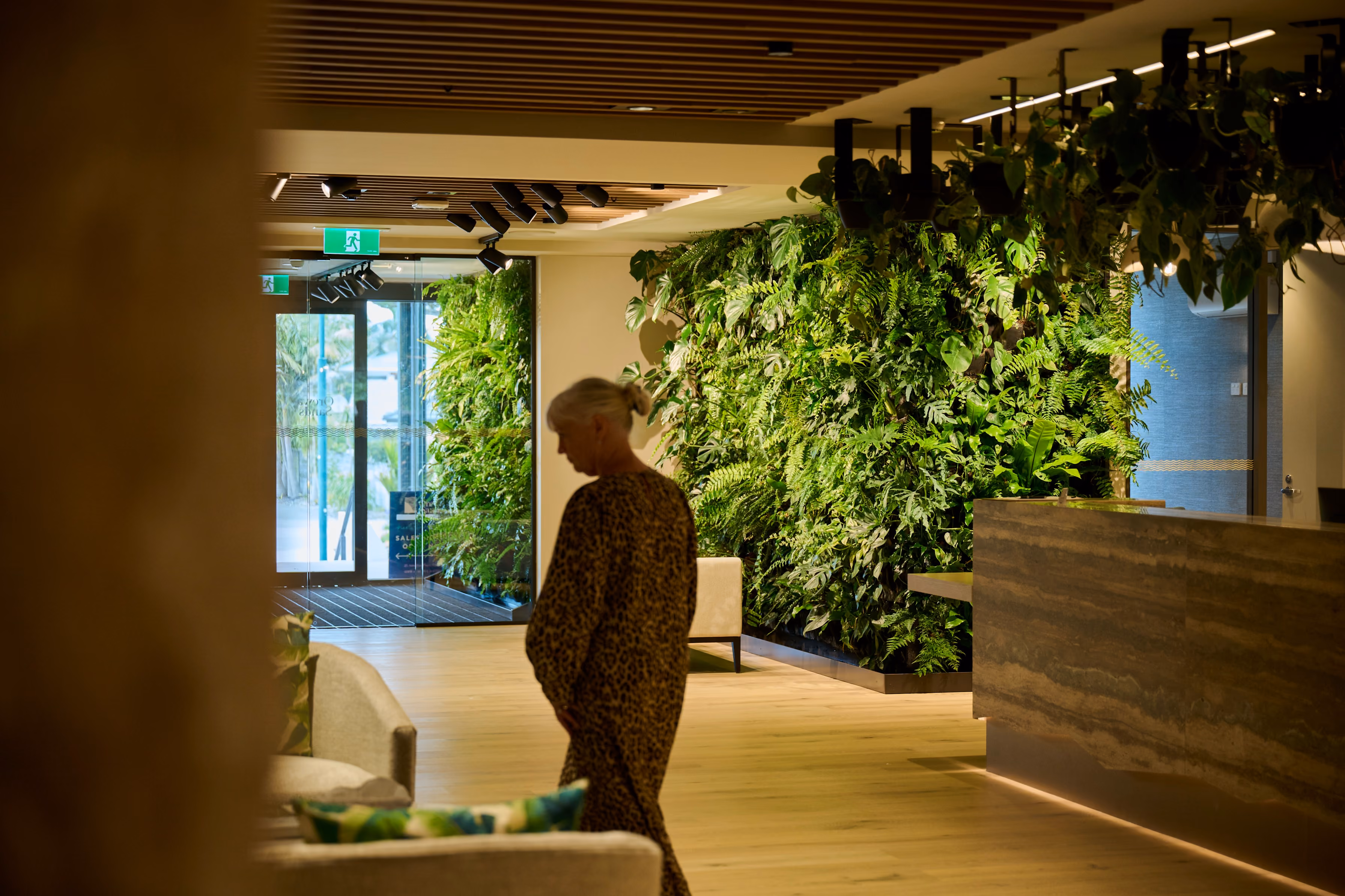 A resident passes a floor-to-ceiling living wall on the way to Orewa's reception.