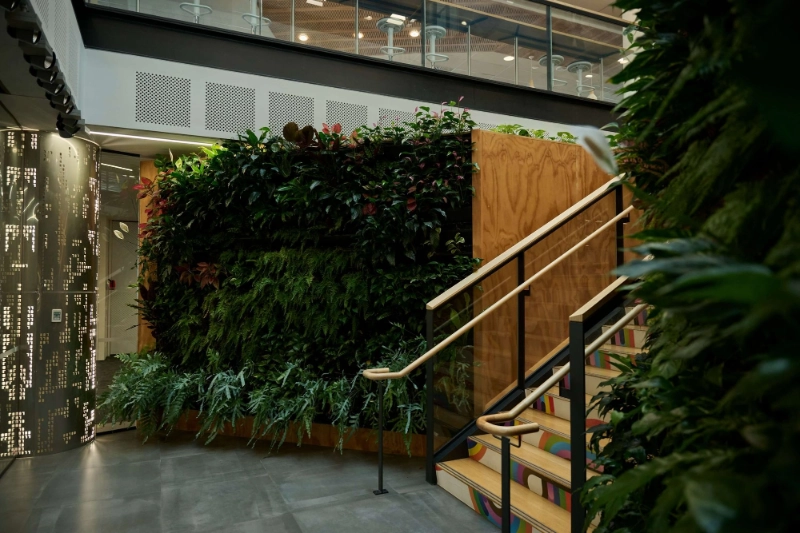 Datacom living wall of lush tropical plants next to the atrium staircase