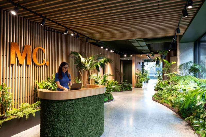 Moss-covered reception desk and tropical planting at the MC Centre entrance