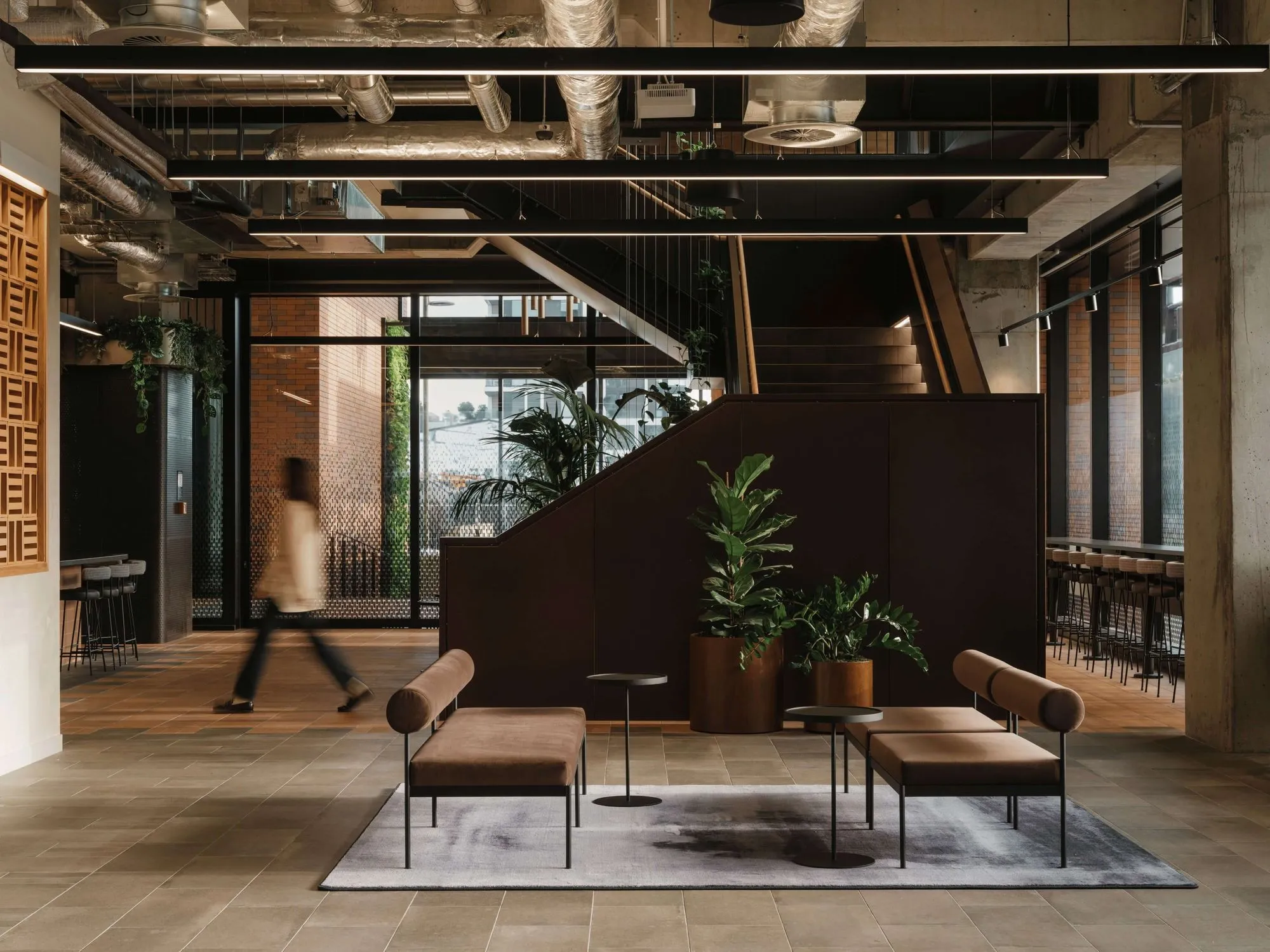 Layered greenery throughout the Mott MacDonald workplace creates a more connected and people-focused environment within the contemporary office setting.