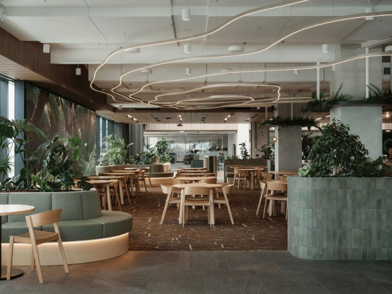 Green-tiled planter and banquette seating beneath curving LED lights at One NZ