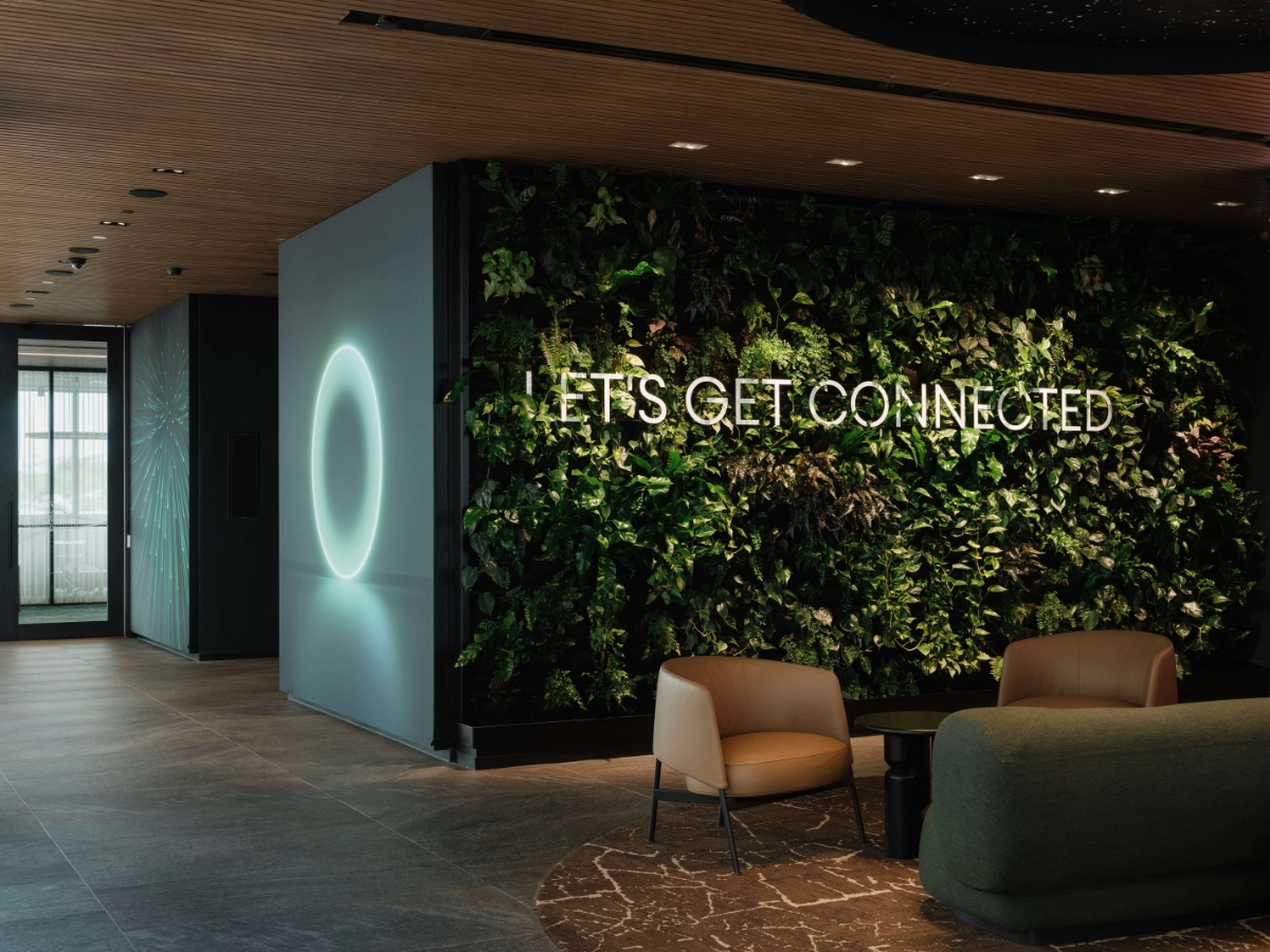 Living green wall with a Let's Get Connected sign and ring light at One NZ